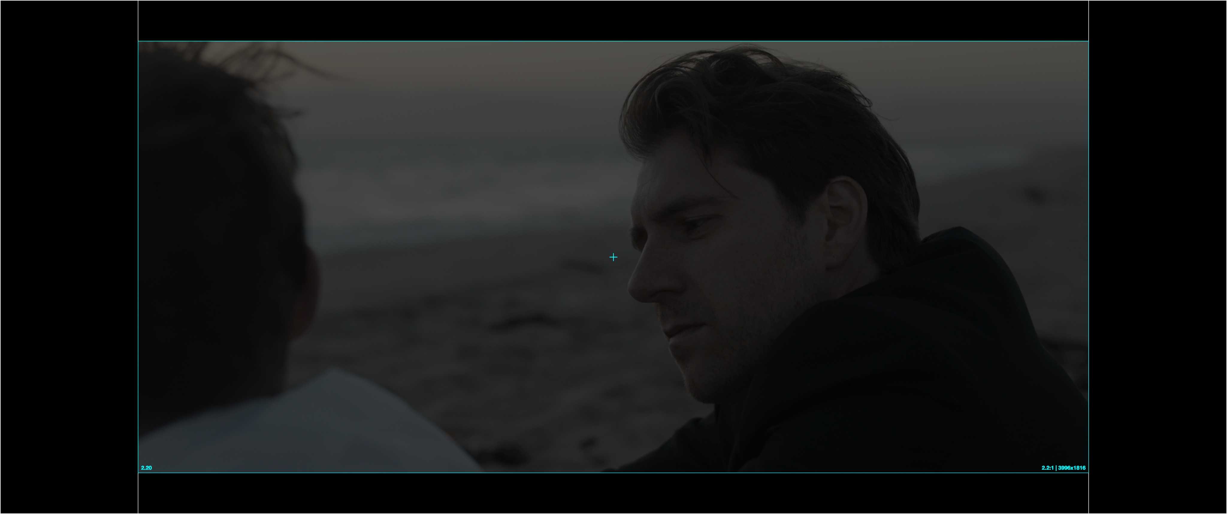 A 2.20:1 active image letterboxed inside a Flat DCP and projected on a Scope-native screen, leaving black bars on all four sides.